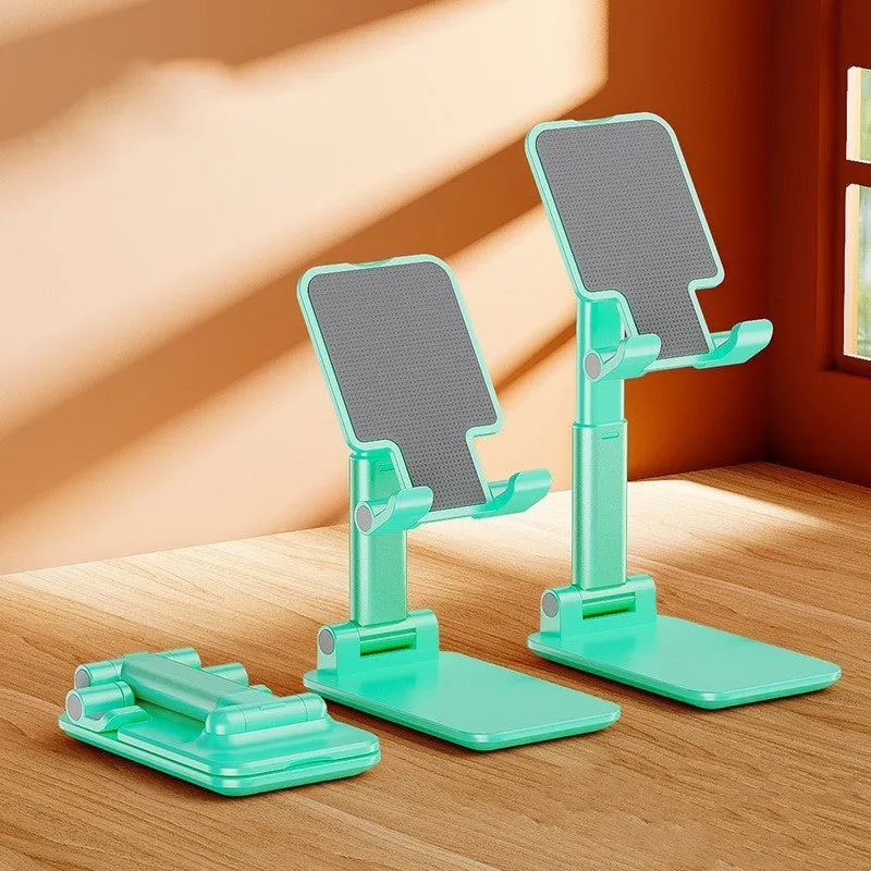 Folding telescopic mobile phone bracket in white, blue, green, or pink colours on a desktop.