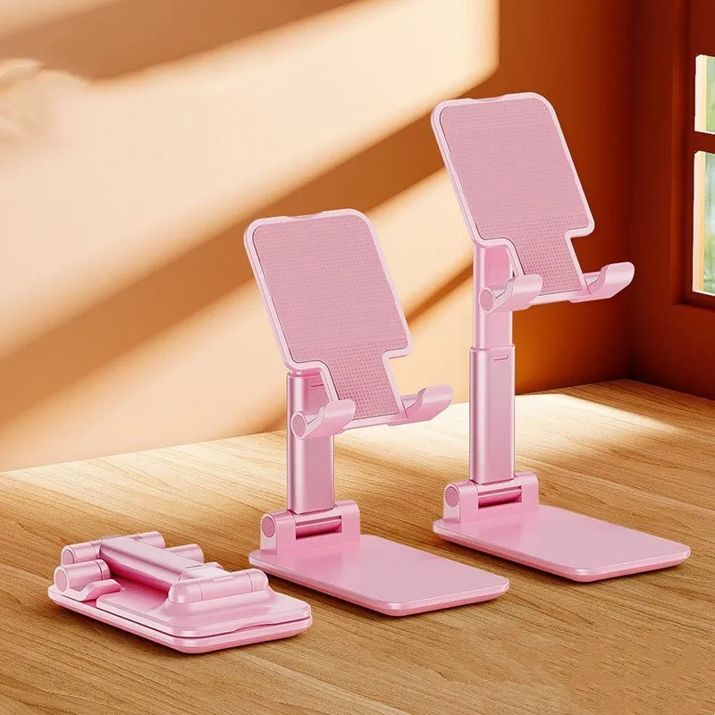 Folding telescopic mobile phone bracket in white, blue, green, or pink colours on a desktop.