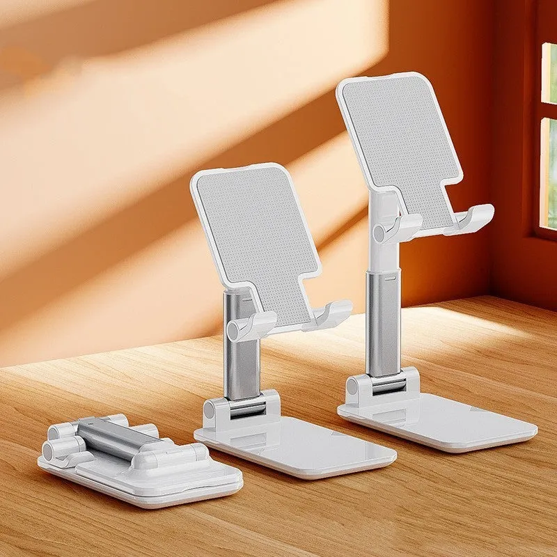 Folding telescopic mobile phone bracket in white, blue, green, or pink colours on a desktop.