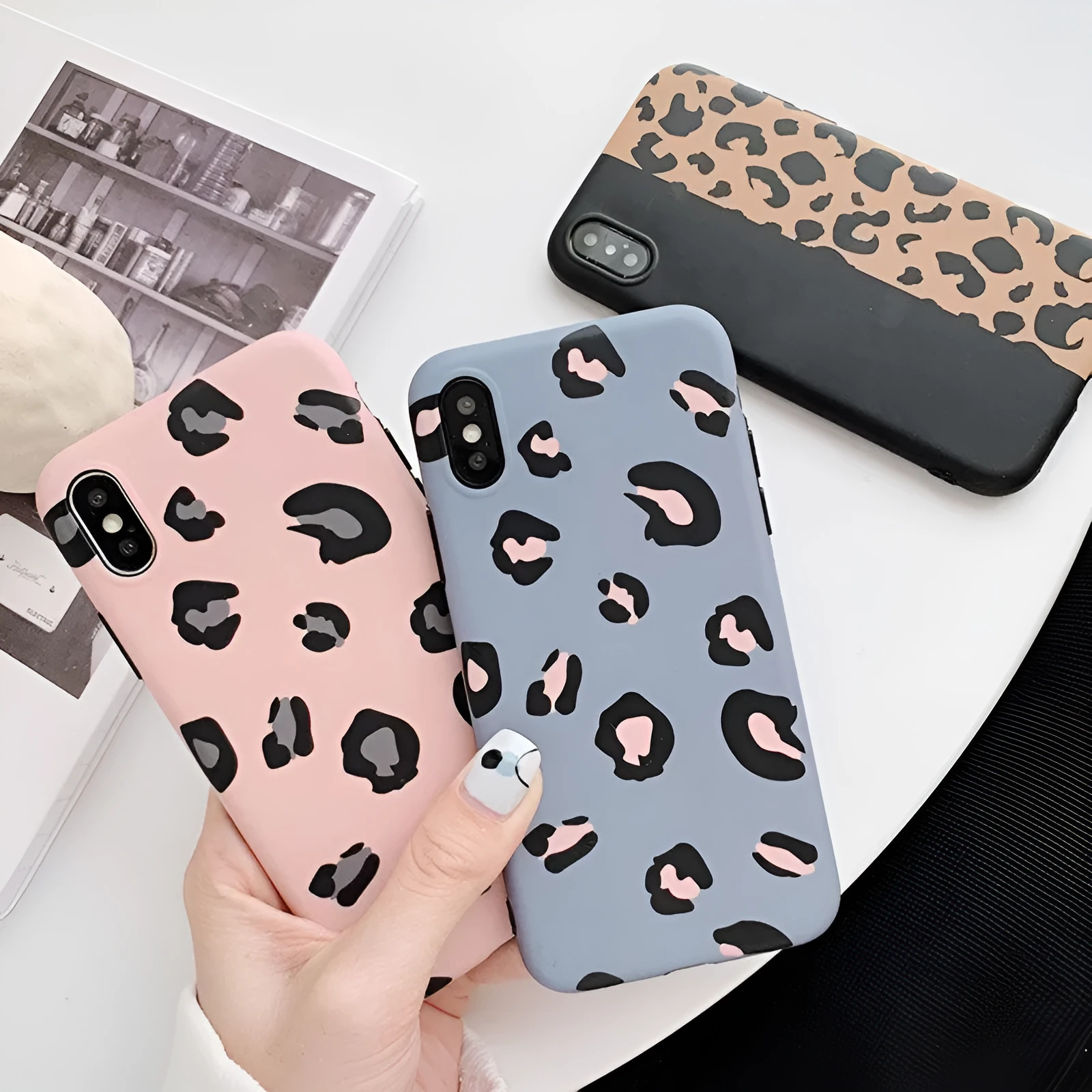 Leopard print phone case for iPhone in black, blue, and pink colours showing front and back views.