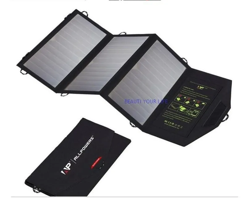 Black foldable solar panel charger with dual USB ports, shown unfolded with mounting loops.