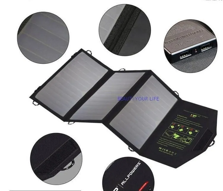 Black foldable solar panel charger with dual USB ports, shown unfolded with mounting loops.