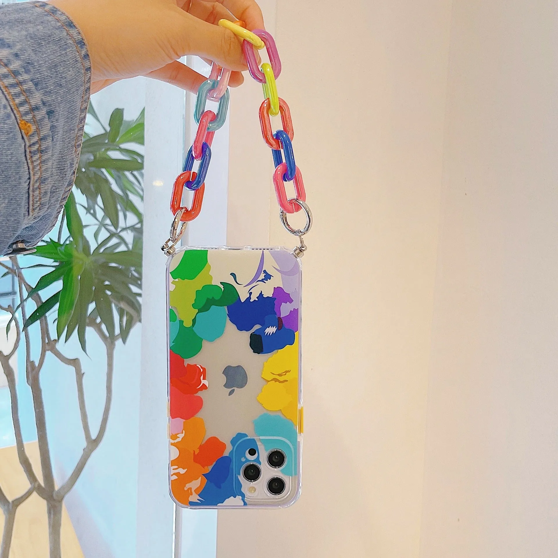 Graffiti design mobile phone case with bracelet strap attached, shown fitting iPhone model