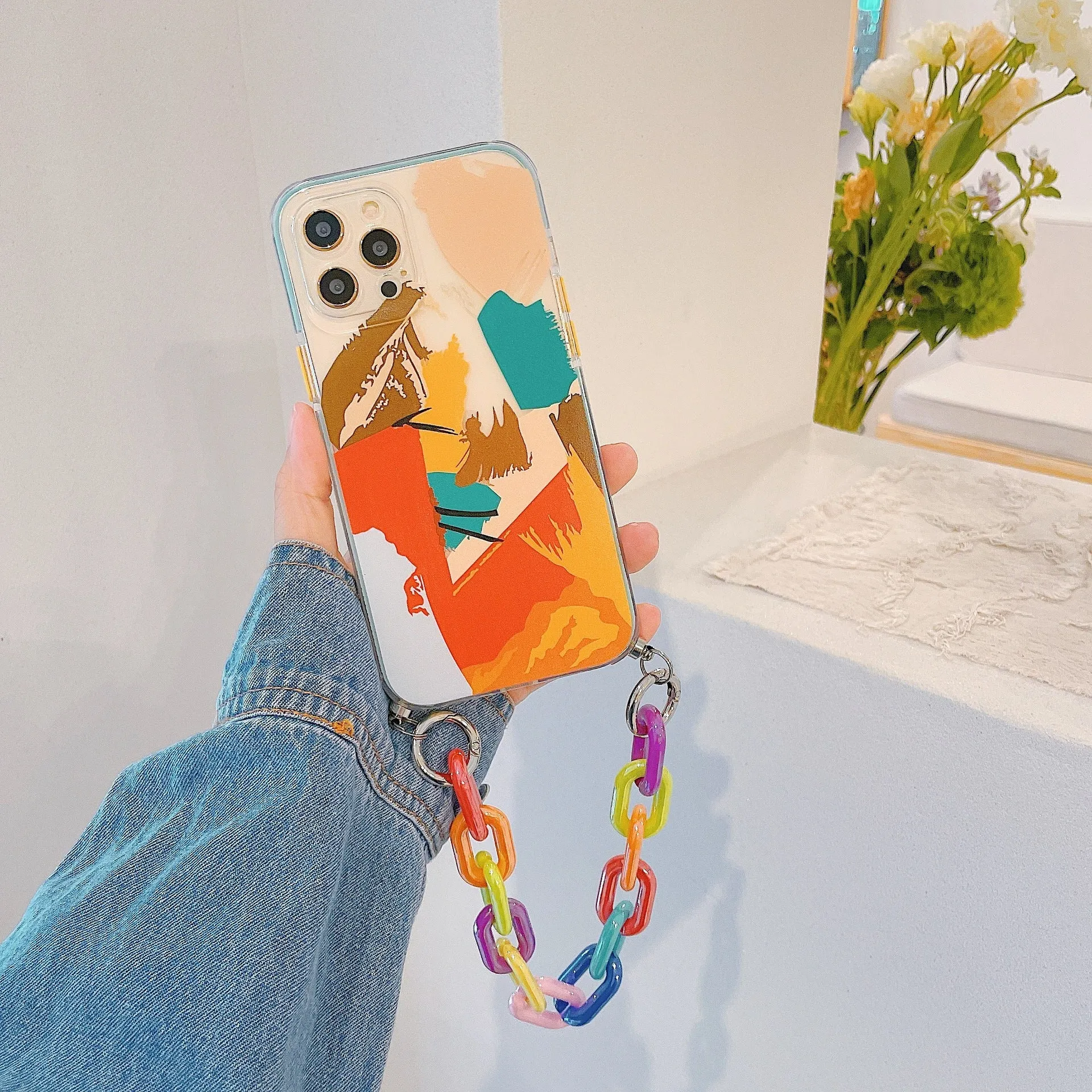 Graffiti design mobile phone case with bracelet strap attached, shown fitting iPhone model