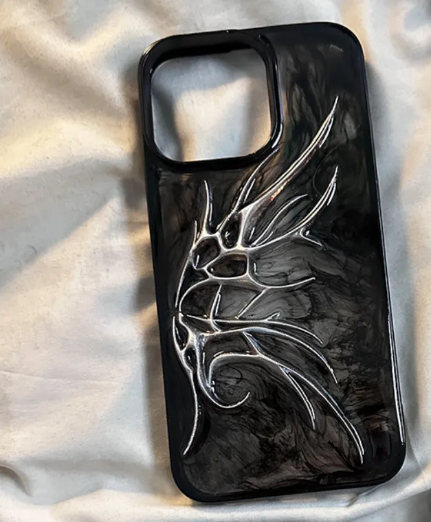 Black iPhone case with three-dimensional blurred wings design showing raised edges and precise port cutouts