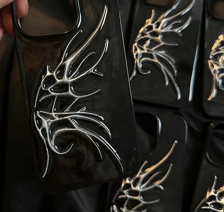 Black iPhone case with three-dimensional blurred wings design showing raised edges and precise port cutouts