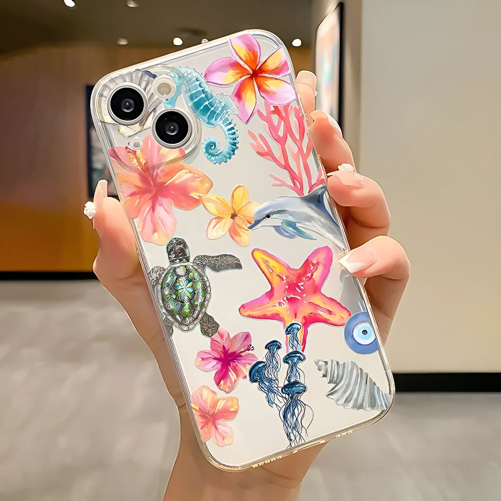 Transparent TPU iPhone case with painted dolphin and turtle design on a phone.