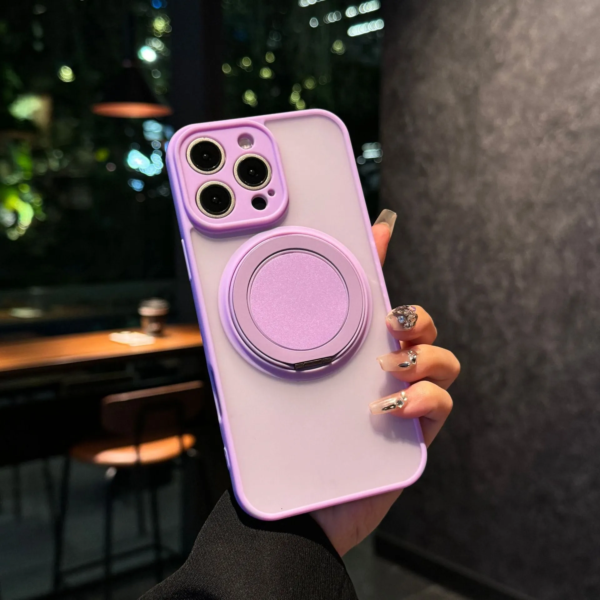 Black frosted phone case for iPhone 17 with a rotating kickstand extended and visible magnetic ring on the back.