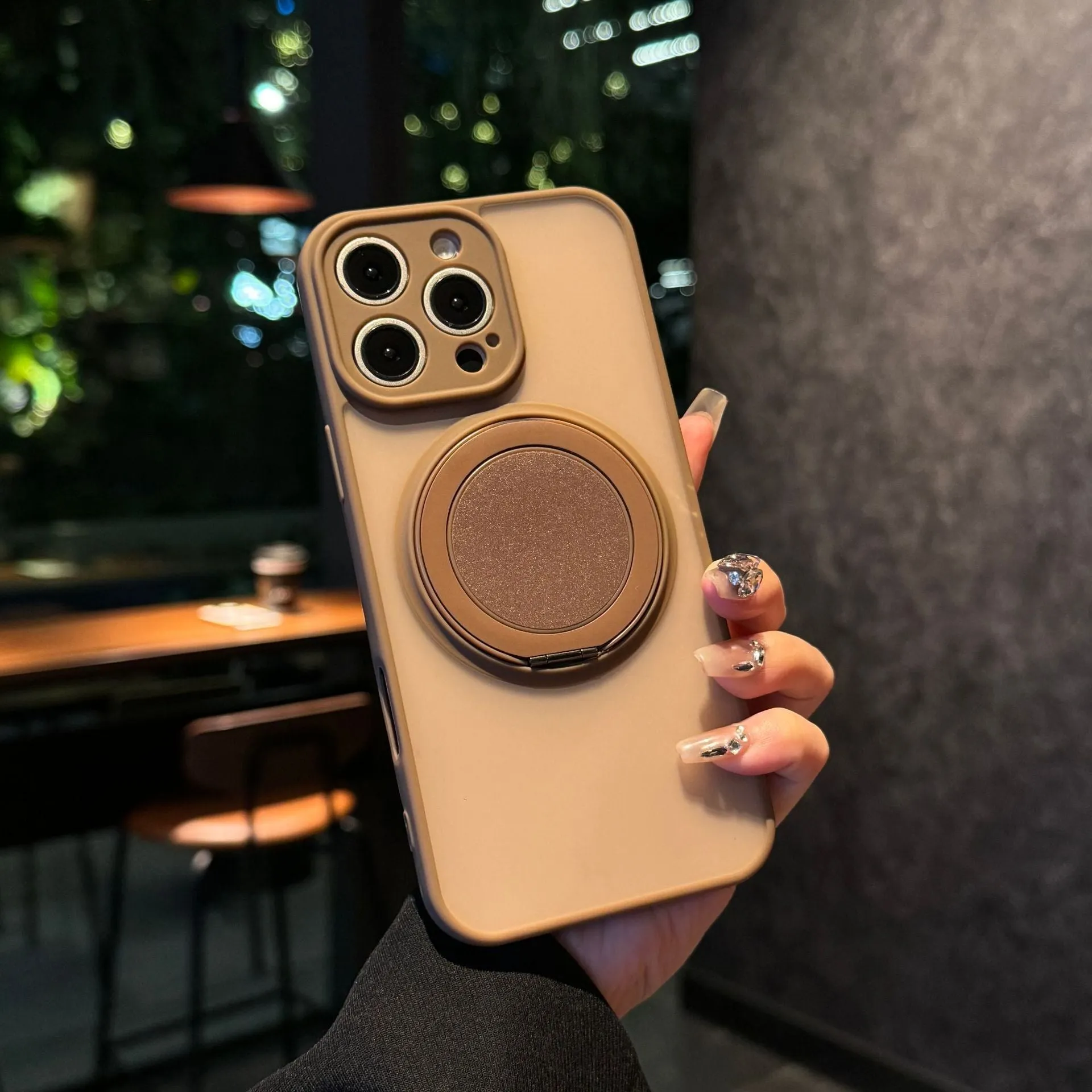 Black frosted phone case for iPhone 17 with a rotating kickstand extended and visible magnetic ring on the back.