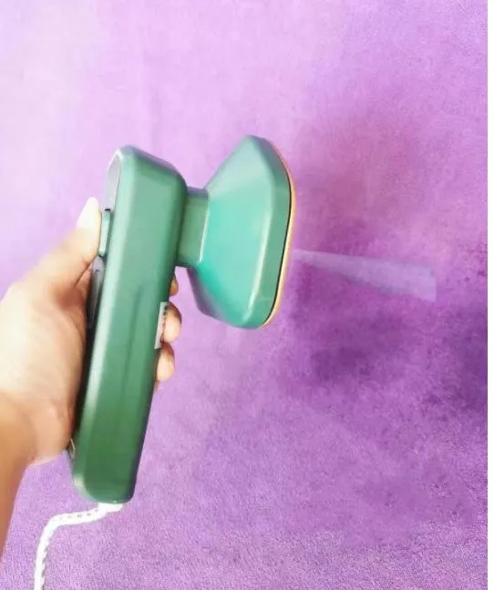 Dark green portable hanging steam ironing machine with ceramic panel.
