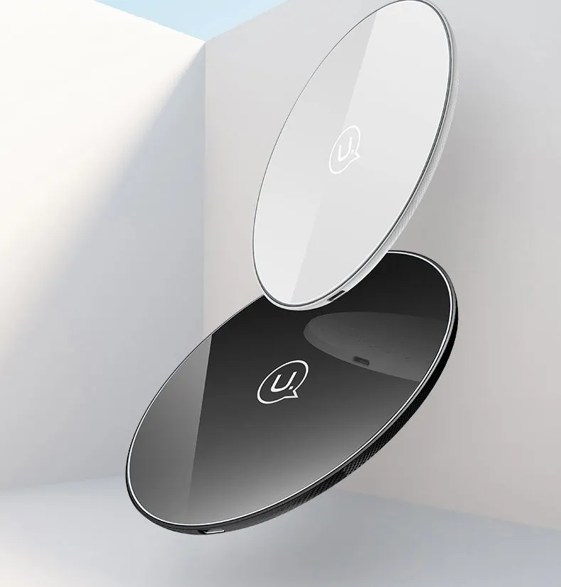 Black or white glass disc wireless charger on a surface, showing status light.