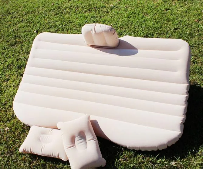 Inflatable car bed with flocked surface folded beside two pillows in storage bag for vehicle sleeping