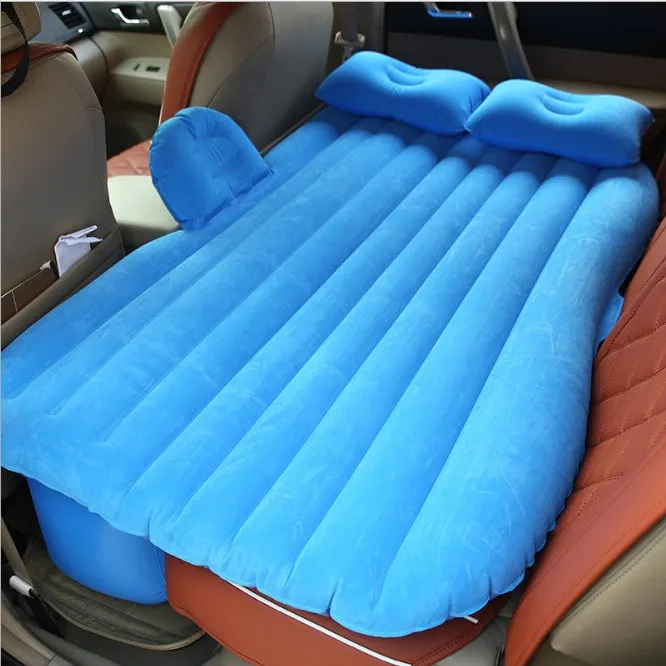 Inflatable car bed with flocked surface folded beside two pillows in storage bag for vehicle sleeping