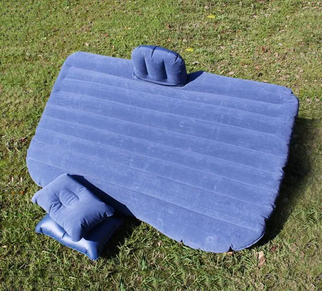Inflatable car bed with flocked surface folded beside two pillows in storage bag for vehicle sleeping