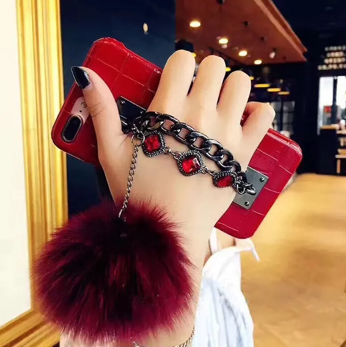 Red iPhone case with rhinestone decoration and attached fox fur ball showing Japanese Korean style design