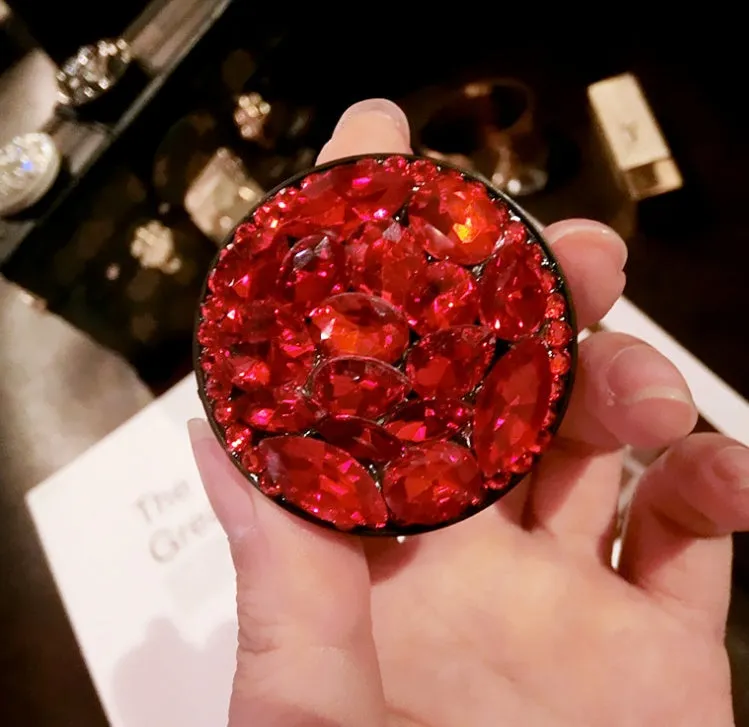 Rhinestone-decorated airbag-style car phone holder with telescopic bracket extended, showing 360-degree swivel mechanism.