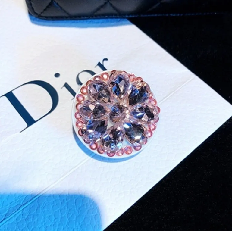 Rhinestone-decorated airbag-style car phone holder with telescopic bracket extended, showing 360-degree swivel mechanism.