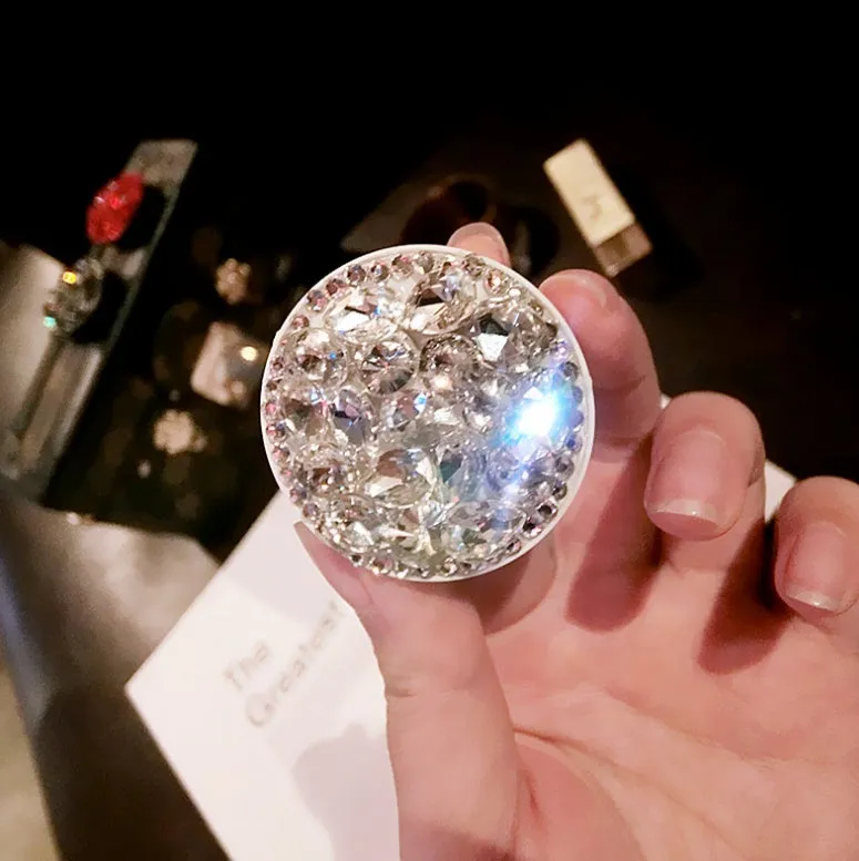 Rhinestone-decorated airbag-style car phone holder with telescopic bracket extended, showing 360-degree swivel mechanism.