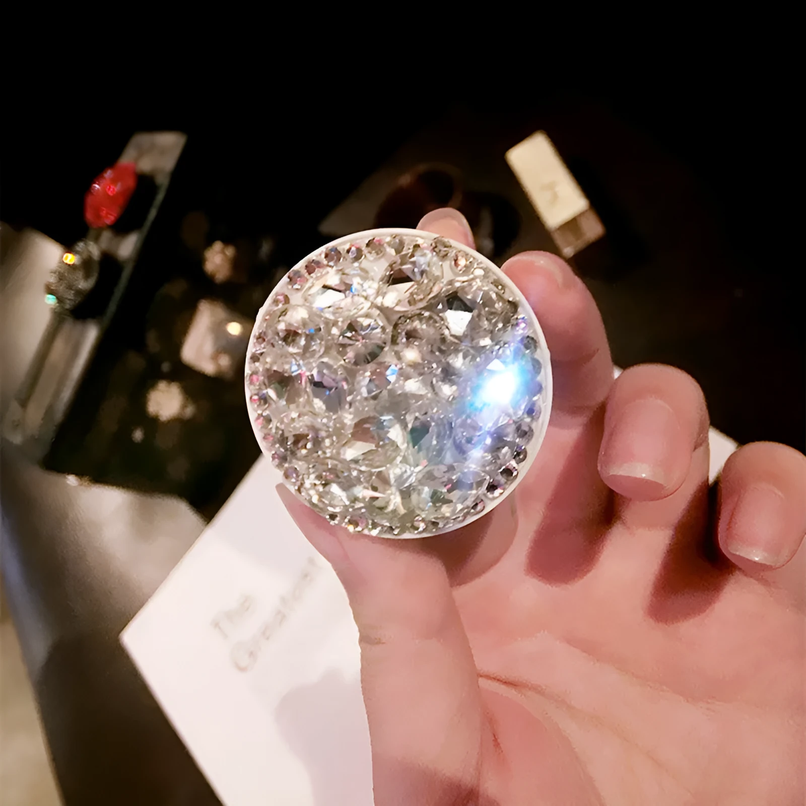 Rhinestone-decorated airbag-style car phone holder with telescopic bracket extended, showing 360-degree swivel mechanism.