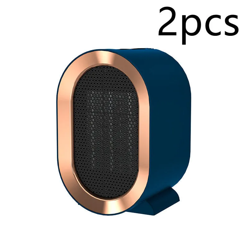 A compact black desktop electric fan heater with mechanical control dials, shown on a wooden desk.