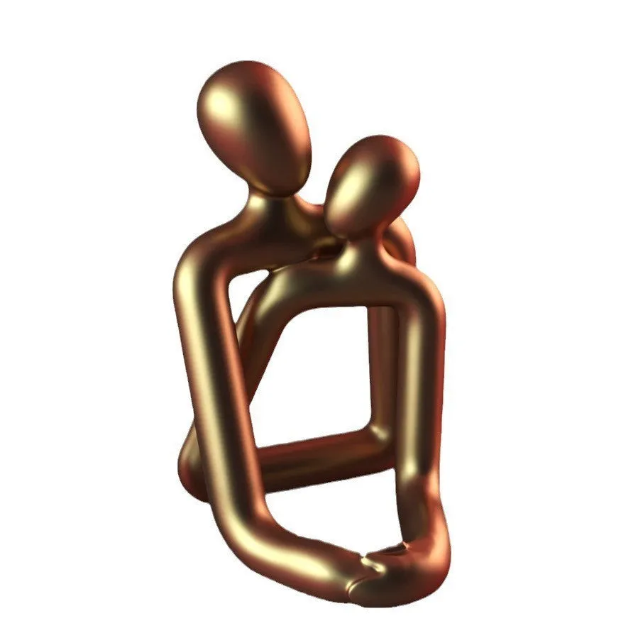 Modern loving couple resin statue in milky white or gold colour on a wooden desk.