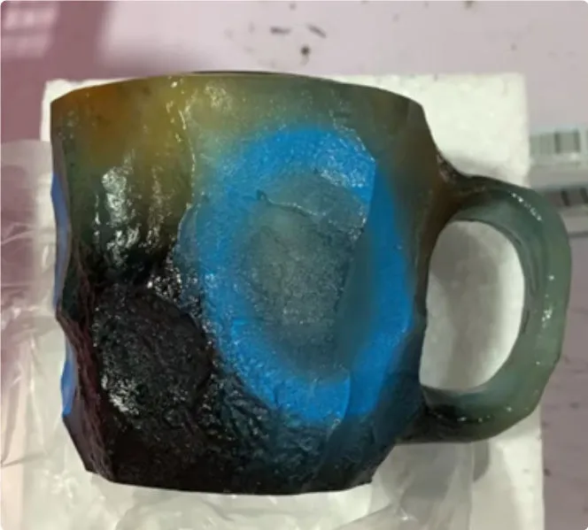 A purple resin coffee mug with a handle, showing a crystal-like structure, on a table.