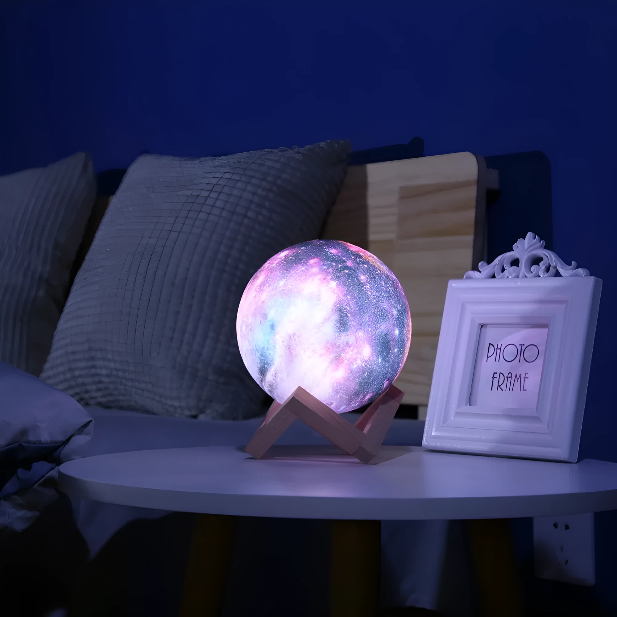 3D-printed white lunar sphere LED night light on a dark surface, showing touch and remote control.