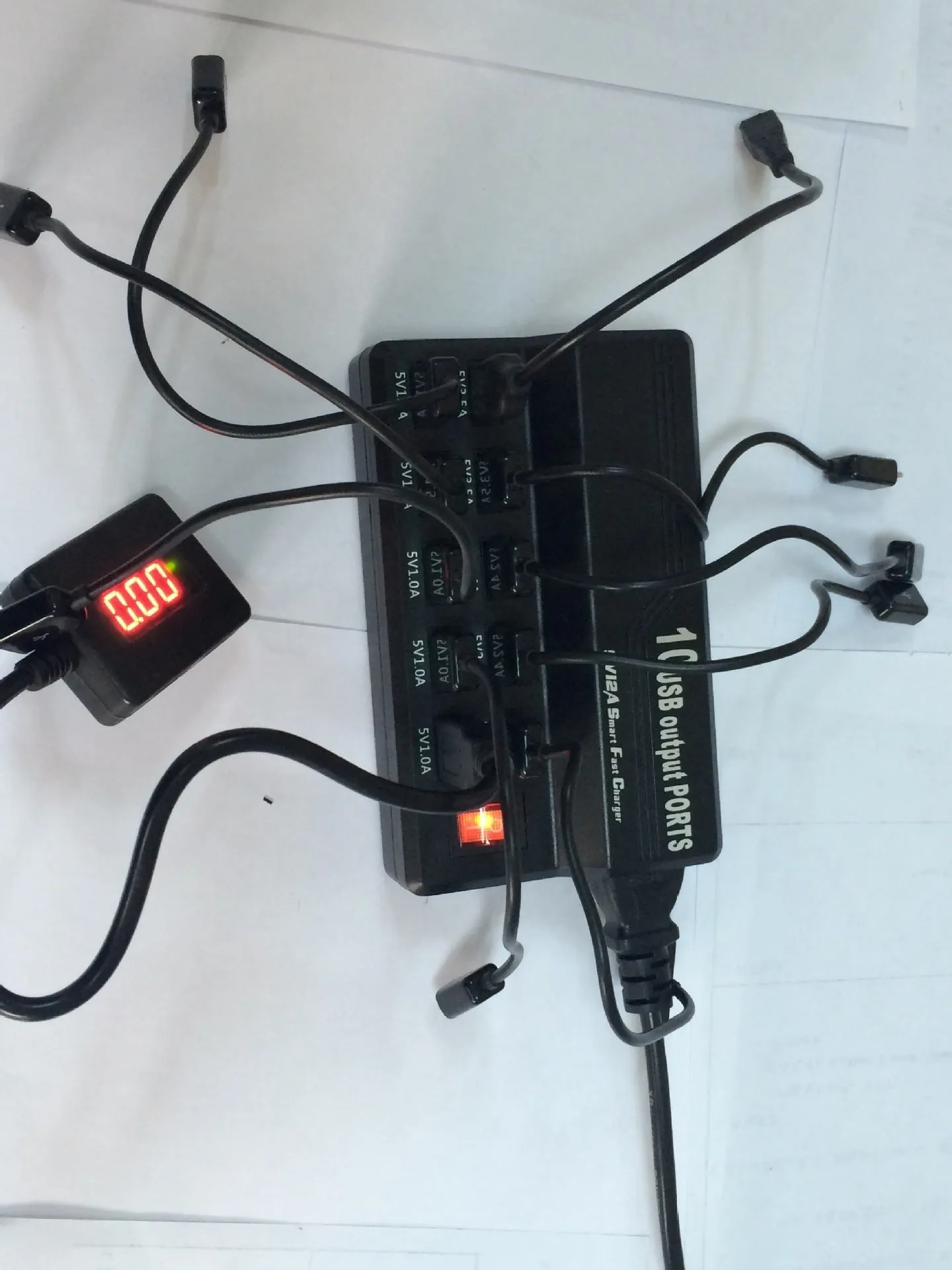 Black 10-port USB charging power strip with smart charging and aluminium heat dissipation, shown with multiple cables connected
