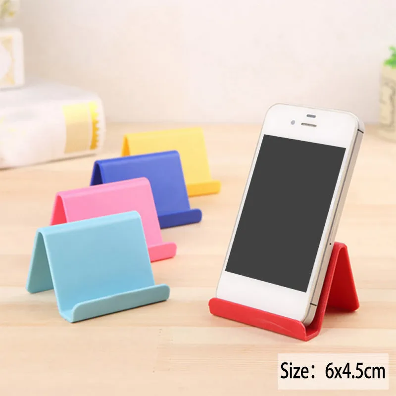 Plastic mobile phone stand in irregular shape on a desk, 6x4.5cm, in blue colour