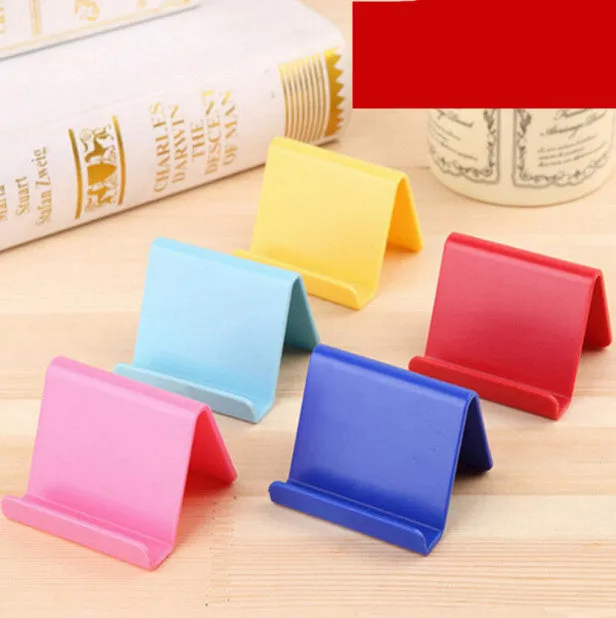 Plastic mobile phone stand in irregular shape on a desk, 6x4.5cm, in blue colour