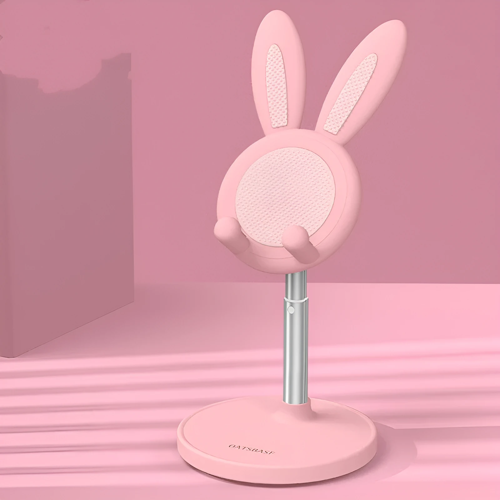 Rabbit-shaped silicone phone stand in pink on a desk with a mobile phone