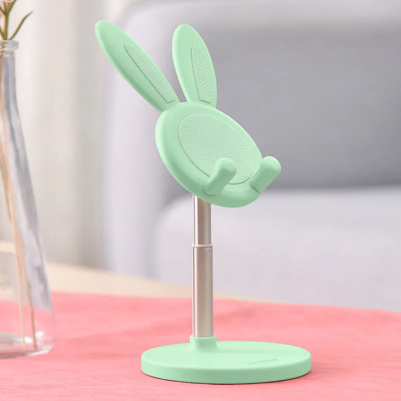 Rabbit-shaped silicone phone stand in pink on a desk with a mobile phone