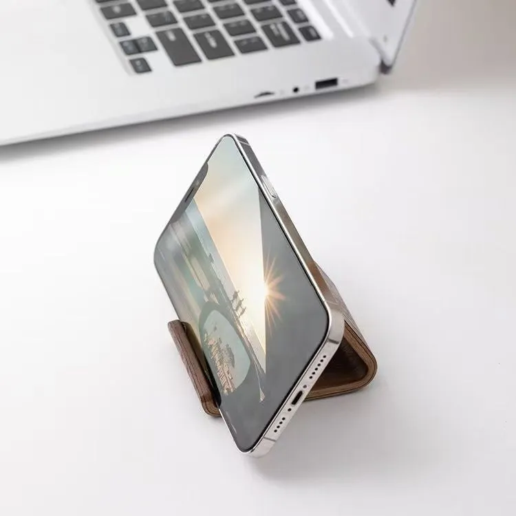 Walnut wood mobile phone bracket holding a smartphone on a wooden desk