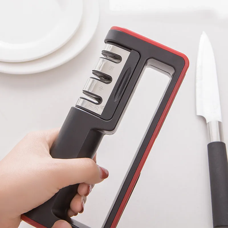 Black and red three-stage knife sharpener with non-skid rubber feet on a worktop