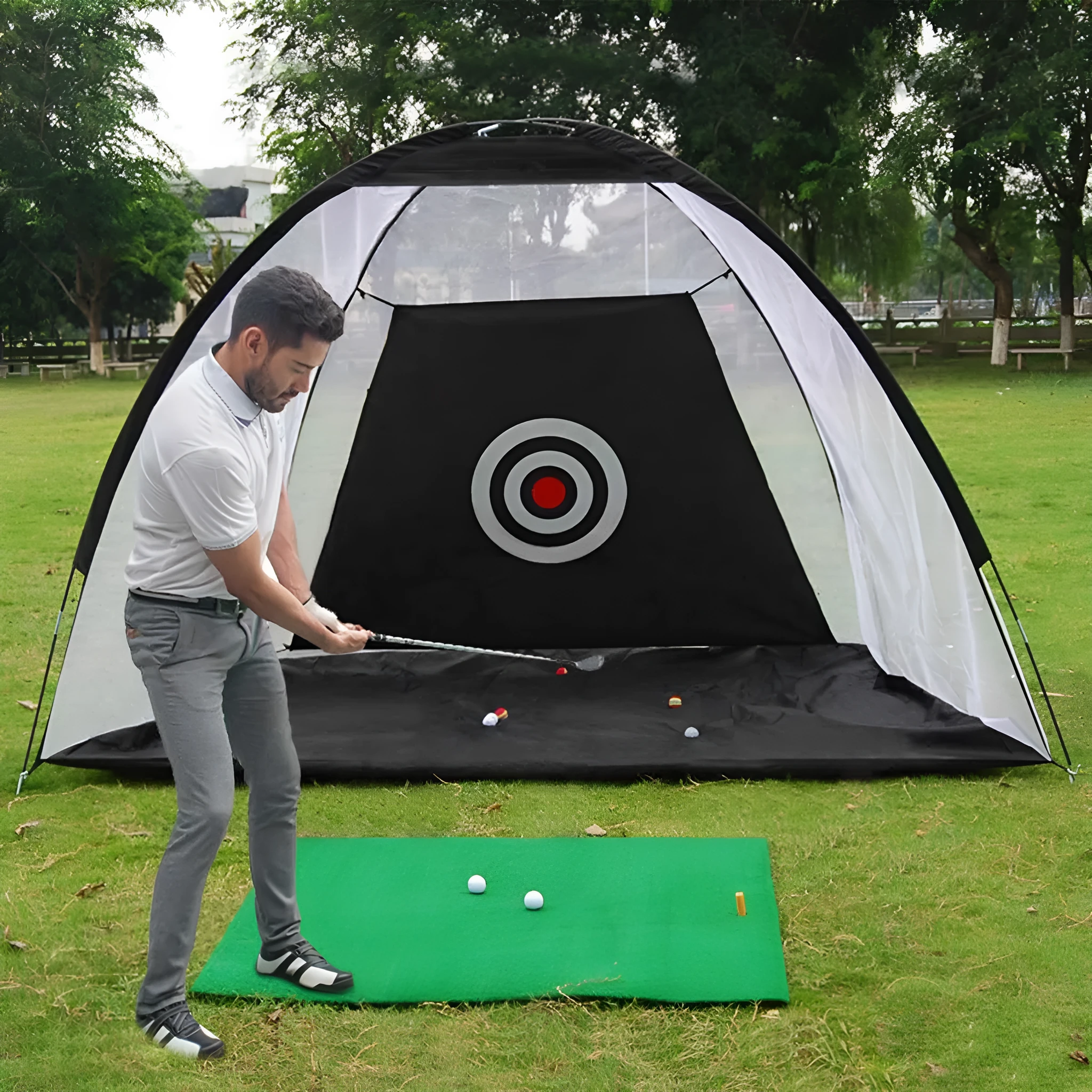 Black and green golf practice net tent set up on grass with fibreglass poles and target sheet