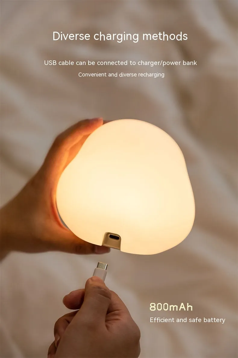 Cute duck shaped LED night lamp with silicone casing and warm light on a bedside table