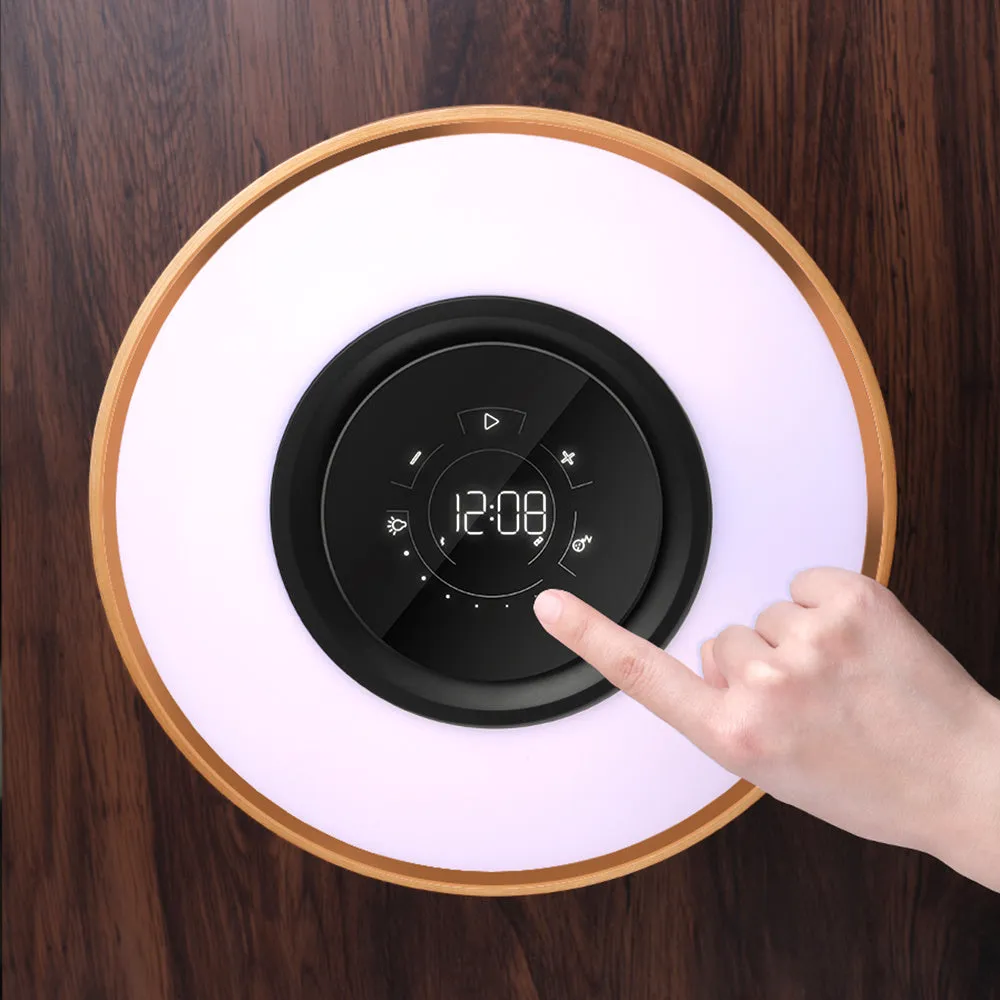 Round maple-coloured ABS PC Bluetooth speaker lamp with LED tree ring and wireless charging pad on a bedside table