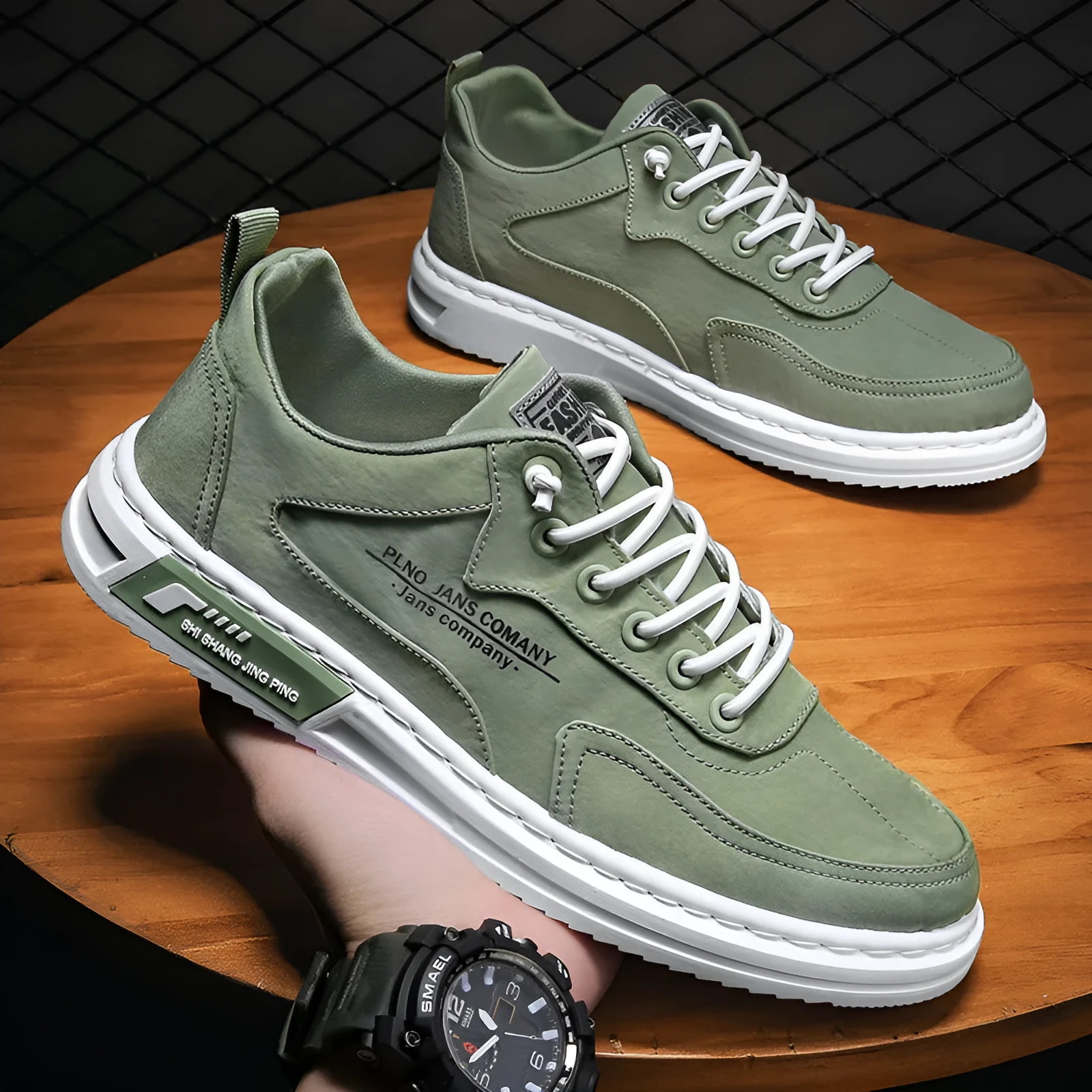 Men's green canvas lace-up sneakers with round toe, flat heel, and letter print side detail on a white background