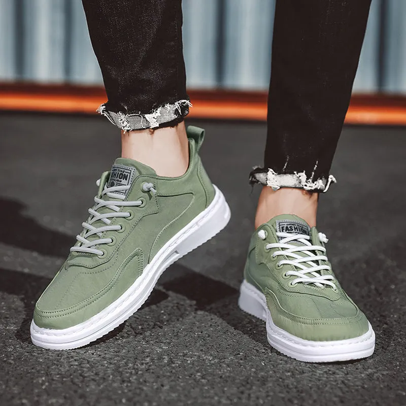 Men's green canvas lace-up sneakers with round toe, flat heel, and letter print side detail on a white background