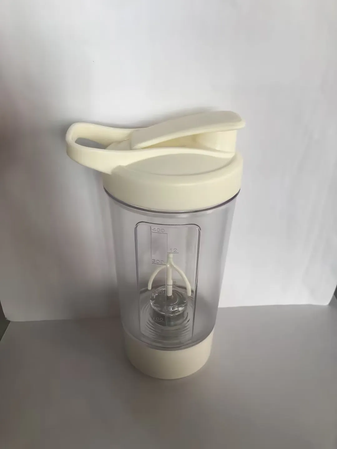 Electric protein shaker bottle 400ml 14oz with black body and white lid, USB charging port visible
