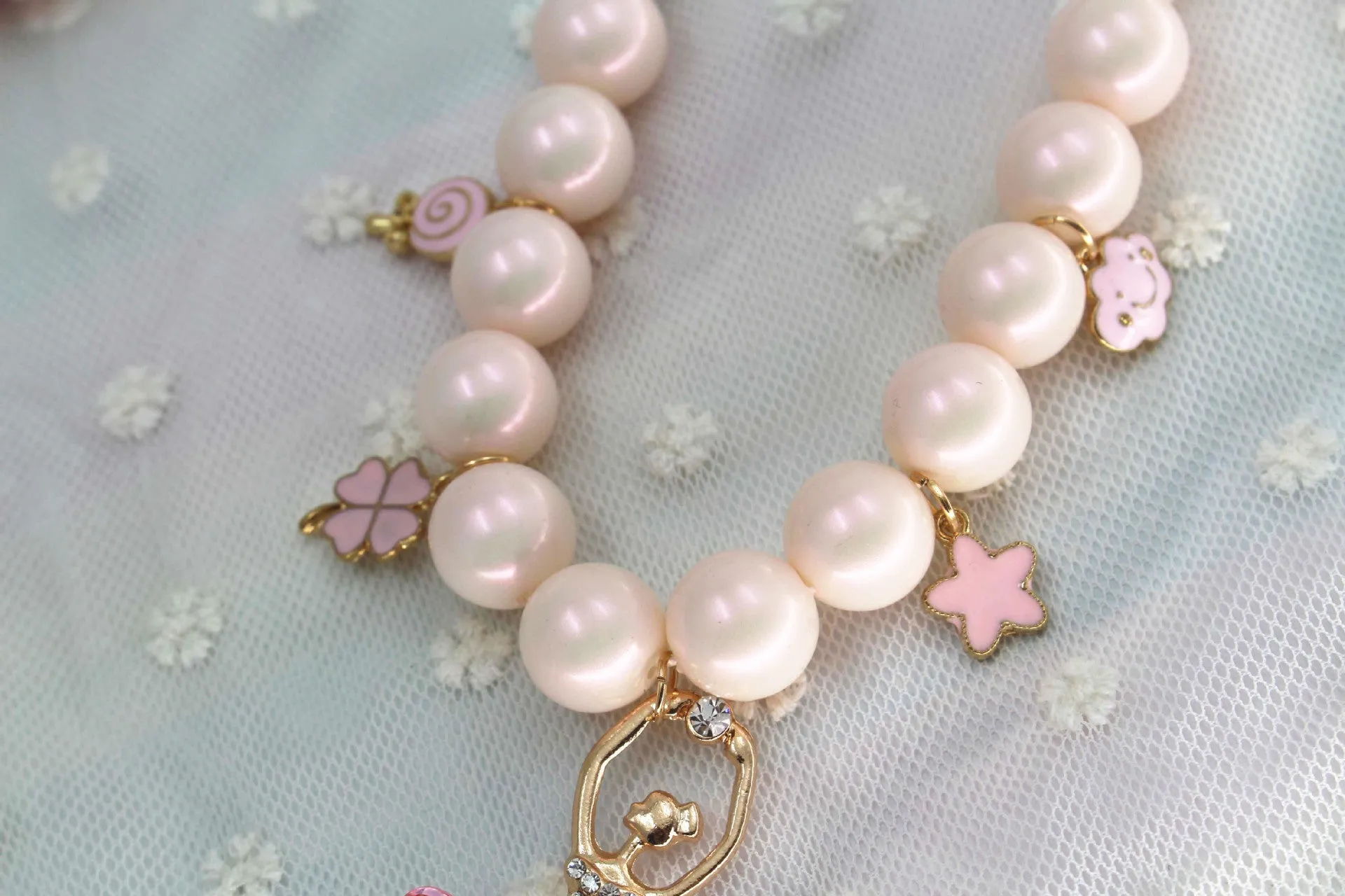 Children's Korean style pearl necklace in Symphony Pink, laid flat on white background