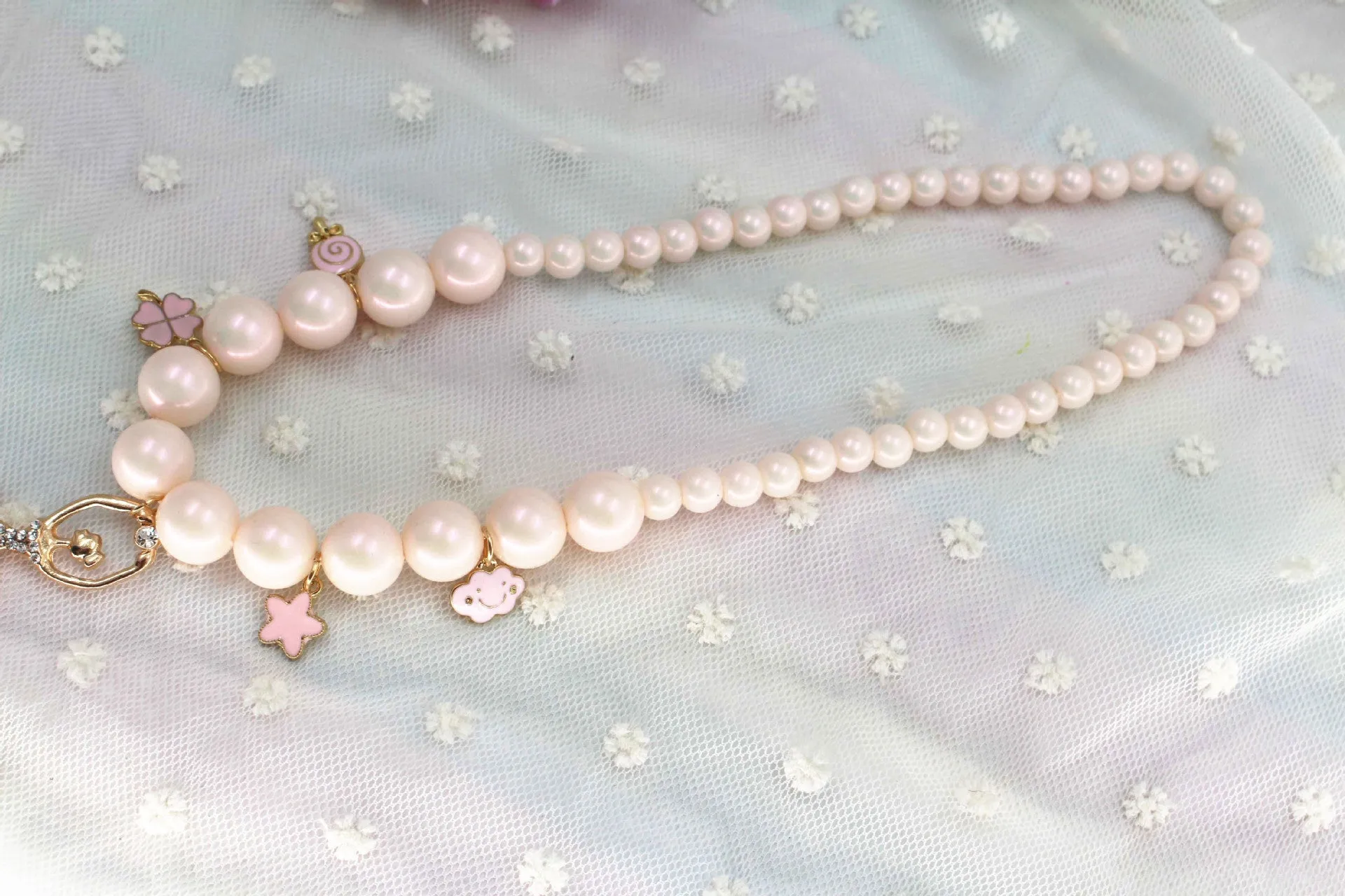 Children's Korean style pearl necklace in Symphony Pink, laid flat on white background