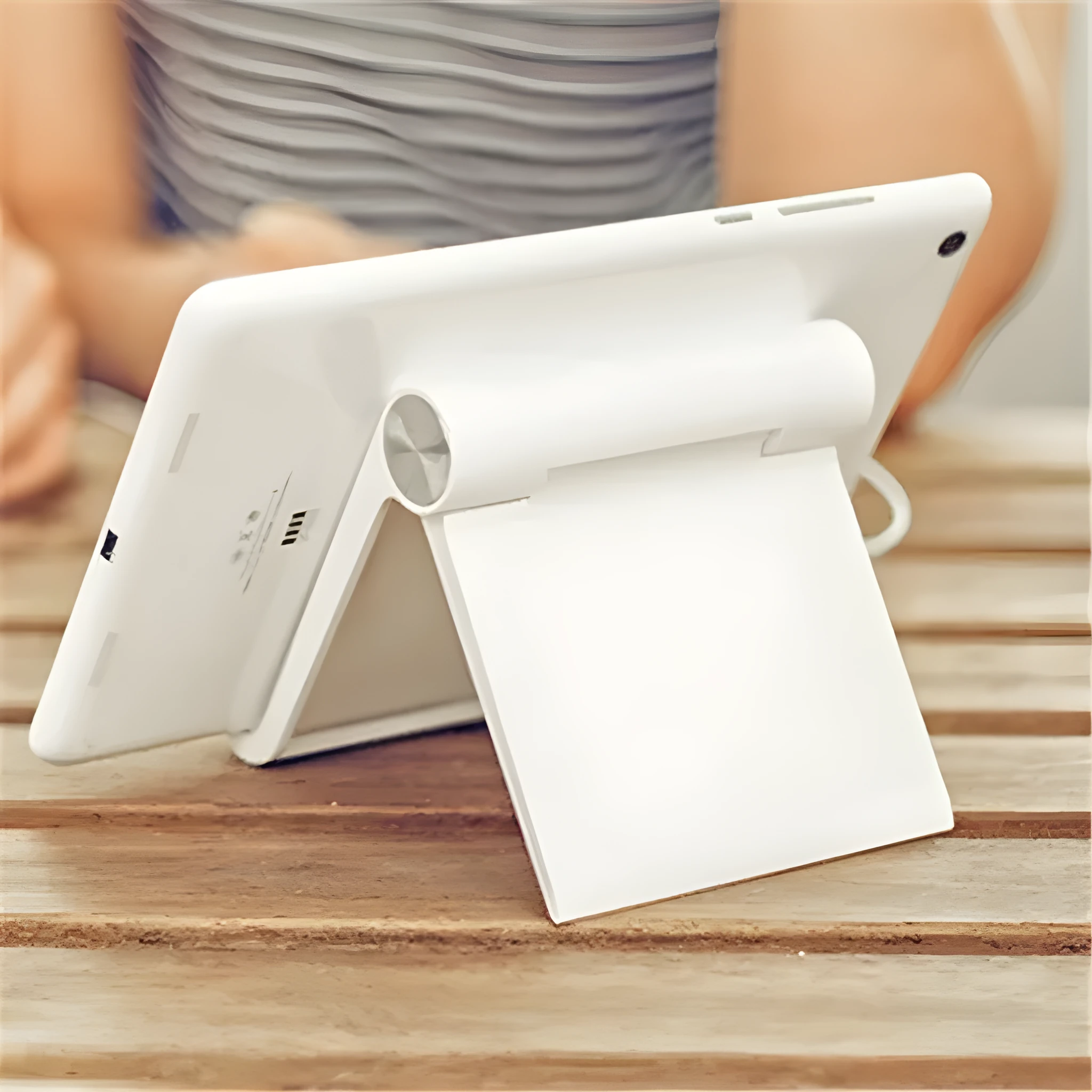 Folding plastic desktop stand holding a smartphone in black colour on a desk