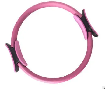 Pink pilates ring with ergonomic design on white background for yoga and home workout resistance training