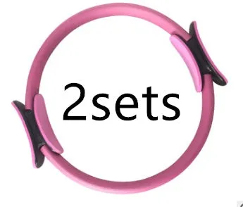 Pink pilates ring with ergonomic design on white background for yoga and home workout resistance training