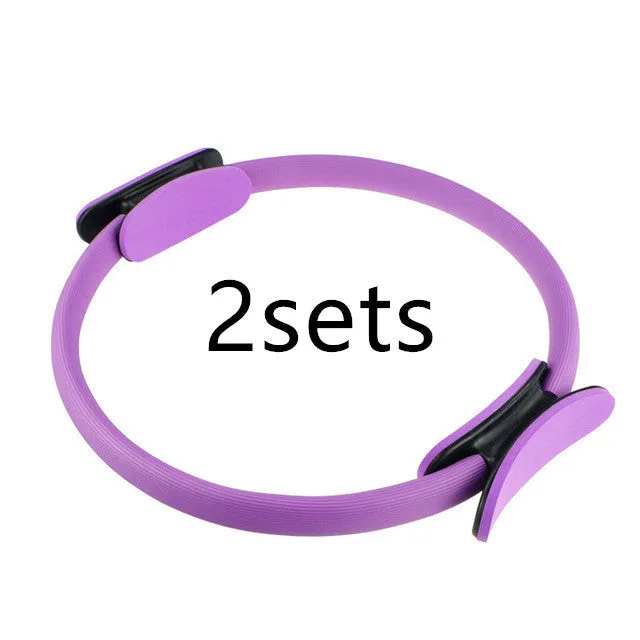 Pink pilates ring with ergonomic design on white background for yoga and home workout resistance training