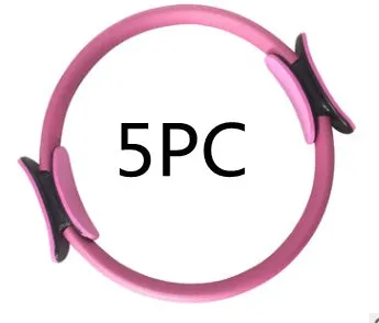 Pink pilates ring with ergonomic design on white background for yoga and home workout resistance training