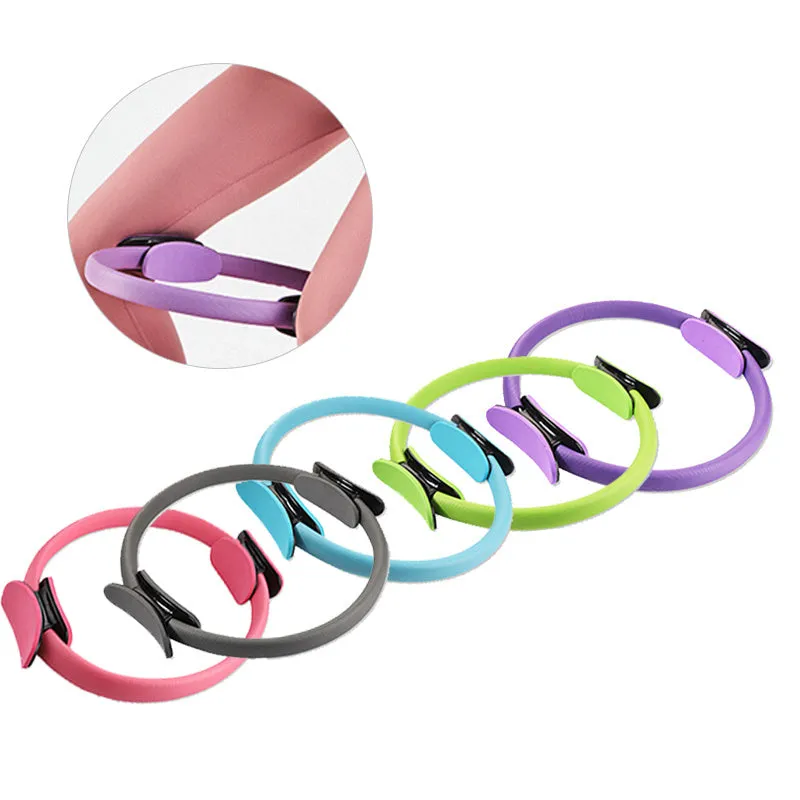 Pink pilates ring with ergonomic design on white background for yoga and home workout resistance training