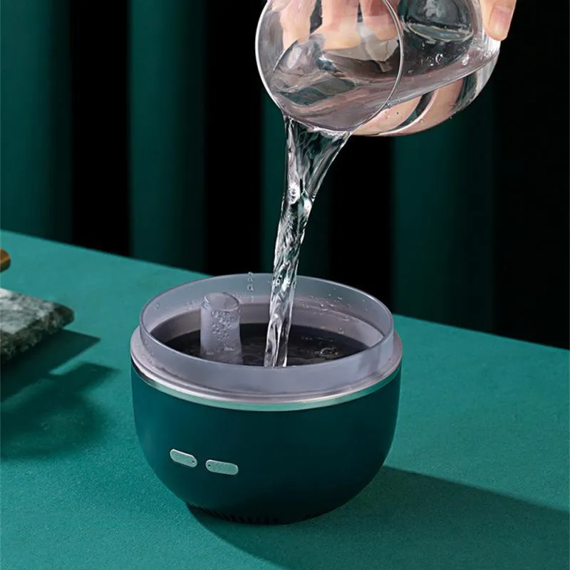 Green ultrasonic aromatherapy humidifier with heavy fog and colourful gradient light on a desk