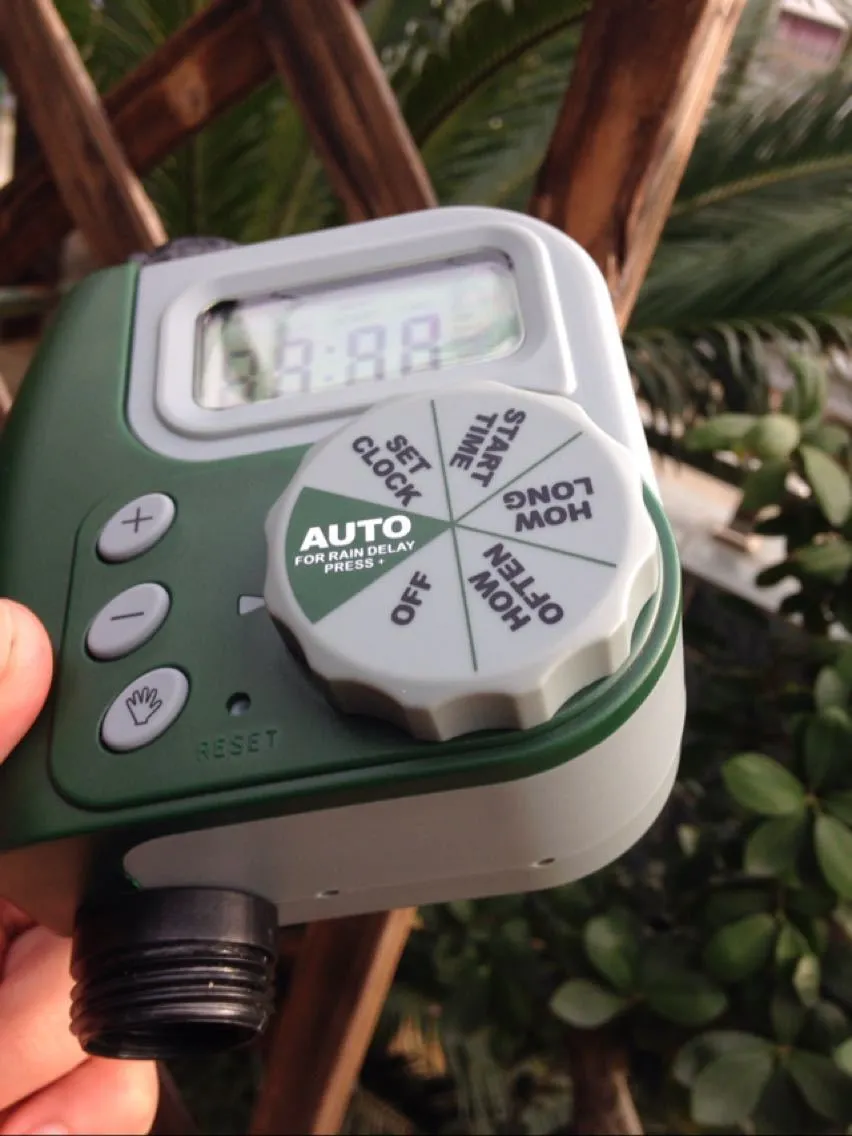Green garden irrigation controller with LCD display and rotary dial for automatic hose timer